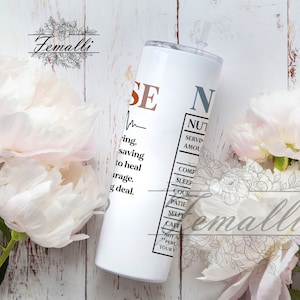 May include: White stainless steel tumbler with a black and brown graphic that reads "Nurse" with a definition of the word. The graphic includes a heart rate line and a nutrition facts label.