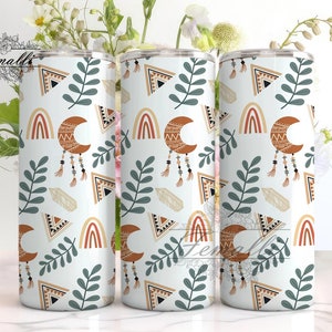 May include: Three stainless steel tumblers with a white background and a pattern of geometric shapes, moons, rainbows, and leaves in shades of brown, orange, and green.