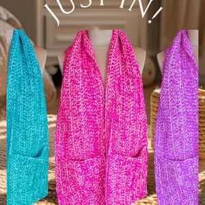 May include: Three crocheted infinity scarves with pockets, one turquoise, one pink, and one purple.