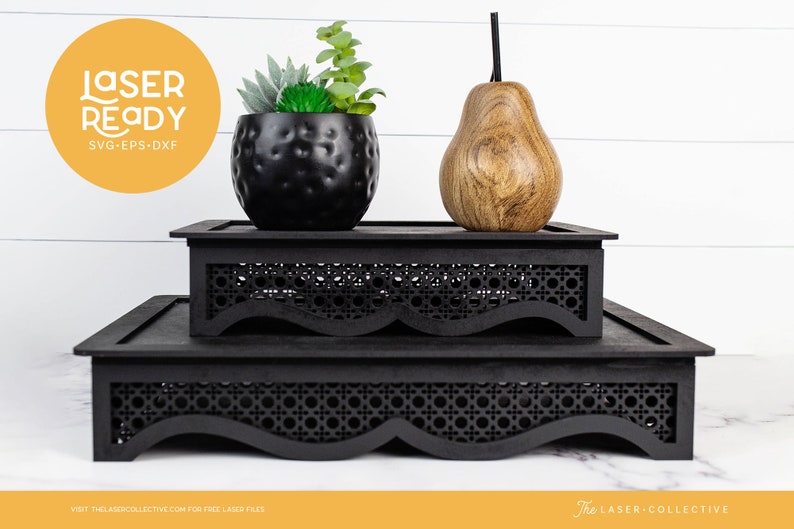 May include: Two black tiered display stands with a woven pattern and scalloped edges. A small potted succulent plant and a wooden pear are on the top tier.