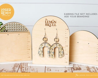May include: Three wooden earring display stands with arched tops. The center stand features the text "The Lemon Skull" and a skull graphic. The left stand has a woven pattern on the top. The right stand is blank. All stands have a white base.