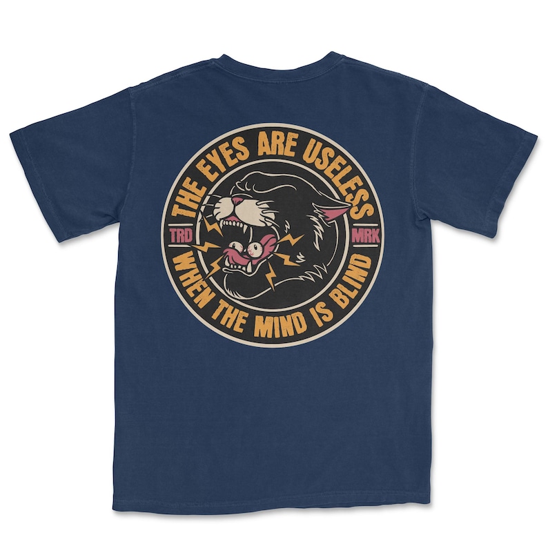A traditional tattoo shirt featuring a panther with eyes in its mouth and the phrase “The eyes are useless when the mind is blind,” printed on a Comfort Colors tee for fans of tattoo art and alternative clothing.