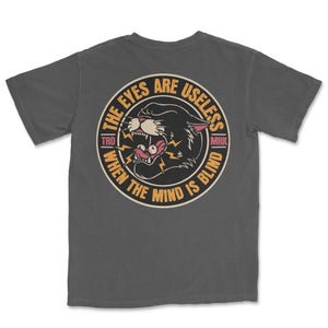 A traditional tattoo shirt featuring a panther with eyes in its mouth and the phrase “The eyes are useless when the mind is blind,” printed on a Comfort Colors tee for fans of tattoo art and alternative clothing.