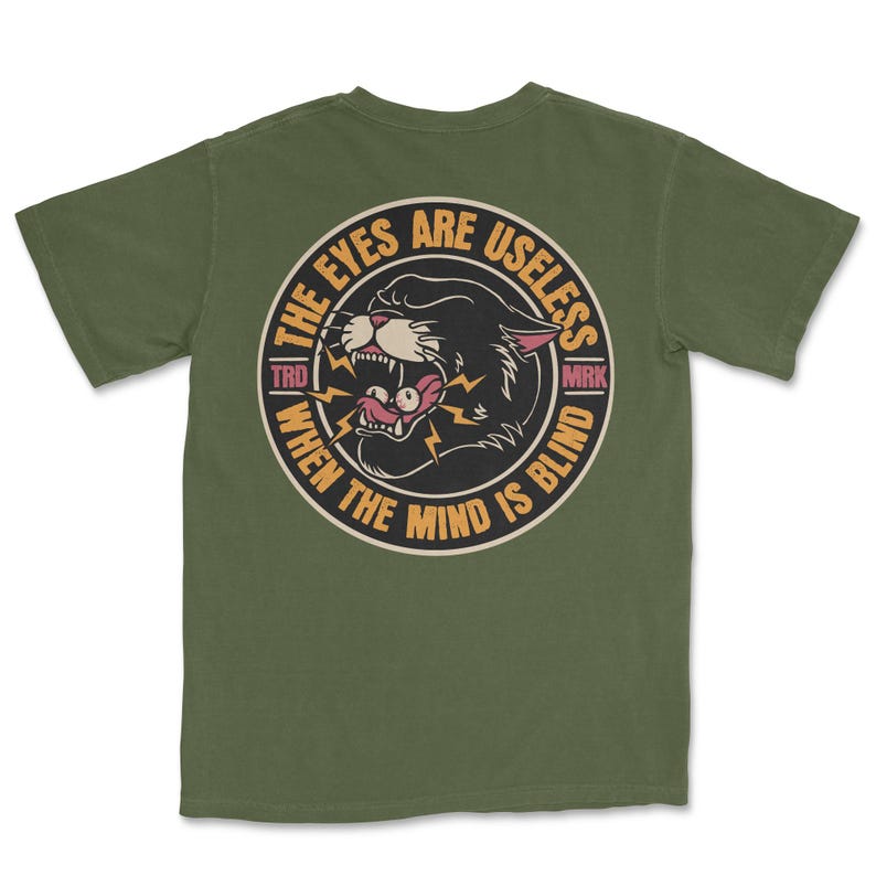 A traditional tattoo shirt featuring a panther with eyes in its mouth and the phrase “The eyes are useless when the mind is blind,” printed on a Comfort Colors tee for fans of tattoo art and alternative clothing.