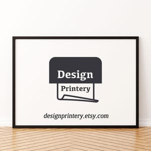 Op de afbeelding: Een zwarte rechthoekige lijst met een witte print met een donkergrijs grafisch icoon van een printer en de tekst Design Printery. Onder de afbeelding staat de tekst designprintery.etsy.com in een zwart schreeflettertype op de witte achtergrond.
