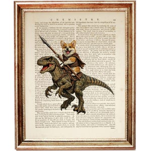 May include: Framed print showing a Corgi riding a dinosaur, holding a spear, set against a vintage book page with the word "CHEMISTRY" at the top. The frame is a warm gold colour. The image has a humorous, fantasy theme.