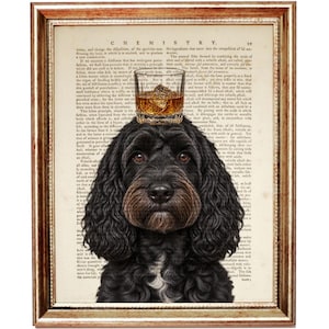May include: A framed wall art print featuring a black dog with long, wavy fur and a white patch on its chest. A glass of amber-colored liquid with ice rests on the dog's head. The background is a page from a vintage chemistry textbook.