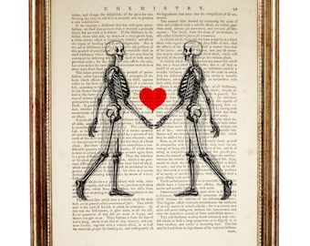 May include: A framed print featuring two black and white skeleton illustrations holding hands over a vintage dictionary page titled CHEMISTRY. A solid red heart is positioned between the skeletons. The frame is a metallic gold with a textured finish.