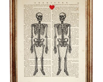May include: A framed print featuring two black and white skeleton illustrations centered over a vintage chemistry textbook page. A small red heart is positioned between the skulls. The frame is metallic gold with a distressed, textured finish.