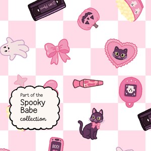 May include: A repeating pattern on a light pink and white checkered background featuring illustrations of black VHS tapes labeled Scary Movies, pink bows, ghosts, a jack-o'-lantern, a black cat, a pink flip phone with BOO! on the screen, and text.