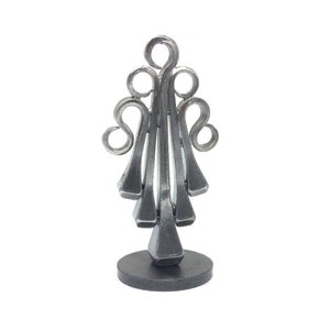 Puede incluir: Una escultura de árbol de Navidad de metal plateado hecha con herraduras reutilizadas. El árbol está sobre una base circular negra.