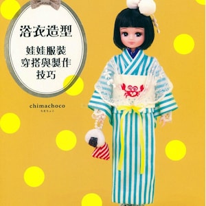 May include: A doll wearing a blue and white striped yukata with a white lace overlay and a yellow sash. The doll has black hair and is holding a white and red onigiri.