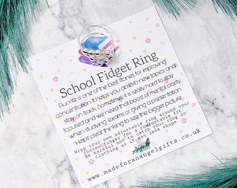 May include: Silver school fidget ring with a card that reads "School Fidget Ring" and explains the benefits of fluorite for concentration and focus. The card also includes the website address "www.madeforanangelgifts.co.uk".