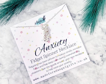 May include: Silver fidget spinner necklace with a card that reads "Anxiety Fidget Spinner Necklace" and includes information about the benefits of fidgeting. The card also includes the website address "www.madeforanangelgifts.co.uk".