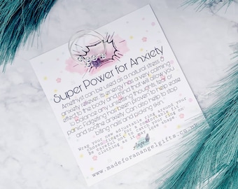 May include: Amethyst ring with a pink and white background. The card reads "Super Power for Anxiety" and explains how amethyst can be used to relieve stress and anxiety. The ring is adjustable and can be worn on any finger.