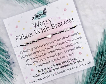 May include: A black string bracelet with silver beads and a silver heart charm. The bracelet is on a white card with pink and yellow floral designs. The card reads "Worry Fidget Wish Bracelet" and includes a description of the bracelet's benefits. The card also includes the website address "www.madeforanangelgifts.co.uk".