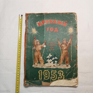 May include: A vintage green book cover with the title "Круглый Год" (Round Year) and the year 1953. The cover features two children in winter clothing skiing with sparklers in the background. The text "Книга-Календарь для Детей" (Book-Calendar for Children) is also visible.