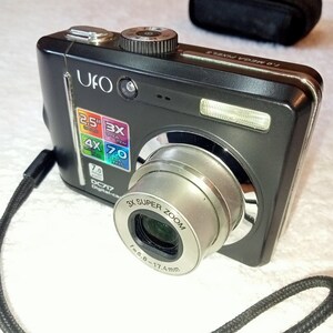 May include: A black digital camera with a silver lens. The camera has a 2.5 inch screen and a 7.0 megapixel resolution. The lens has a 3x super zoom and a focal length of 5.8-17.4mm.