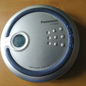 Puede incluir: Un reproductor de CD port&aacute;til plateado y azul con una pantalla digital que muestra "5 16:30". El reproductor tiene botones para el volumen, el salto y otras funciones. El texto "Panasonic SL-SX320" y "Anti-Skip System" est&aacute; impreso en el reproductor.