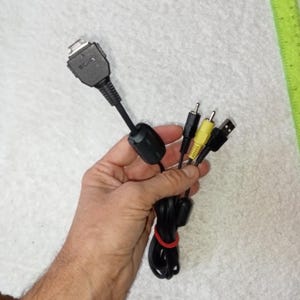 Może przedstawiać: Czarny kabel z trzema złączami: złączem USB, żółtym złączem RCA i czarnym złączem RCA. Kabel jest oznaczony napisem "SONY".