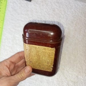 Op de afbeelding: Een bruine plastic container met een label waarop staat "Огненная жидкость для зажигания. Огнеопасно!"
