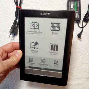 Puede incluir: Un lector electrónico Sony negro con una pantalla de tinta electrónica de 6 pulgadas. La pantalla muestra un menú con opciones para "Continuar leyendo", "Libros", "Todas las notas", "Colecciones", "Memo de texto", "Escritura a mano" y "Más".