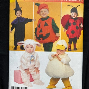 May include: Simplicity sewing pattern number 2788 for toddler costumes. The pattern includes five costumes: a witch, a pumpkin, a ladybug, a lamb, and a duck. The pattern is for sizes 1/2, 1, 2, 3, and 4.