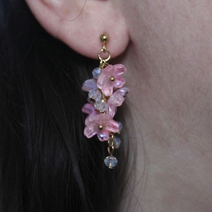 May include: Pink and purple flower dangle earrings with gold accents and crystal beads.