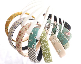 May include: Assortment of fabric-covered headbands in various floral and geometric patterns, including green, brown, beige, and blue.