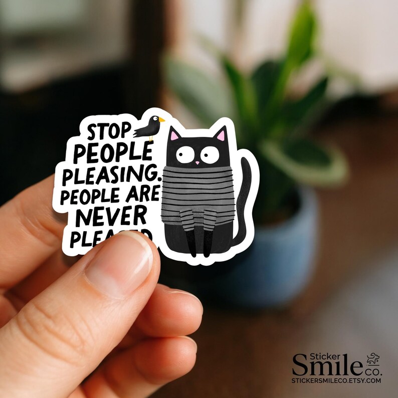 May include: A die-cut sticker featuring a black cat with wide eyes wearing a gray and black striped sweater. Next to the cat is a small black bird. The text reads: STOP PEOPLE PLEASING. PEOPLE ARE NEVER PLEASED. The sticker has a white border.