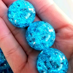 K&ouml;nnte beinhalten: Drei runde, blaue Glasmurmeln mit einem funkelnden, schillernden Finish.