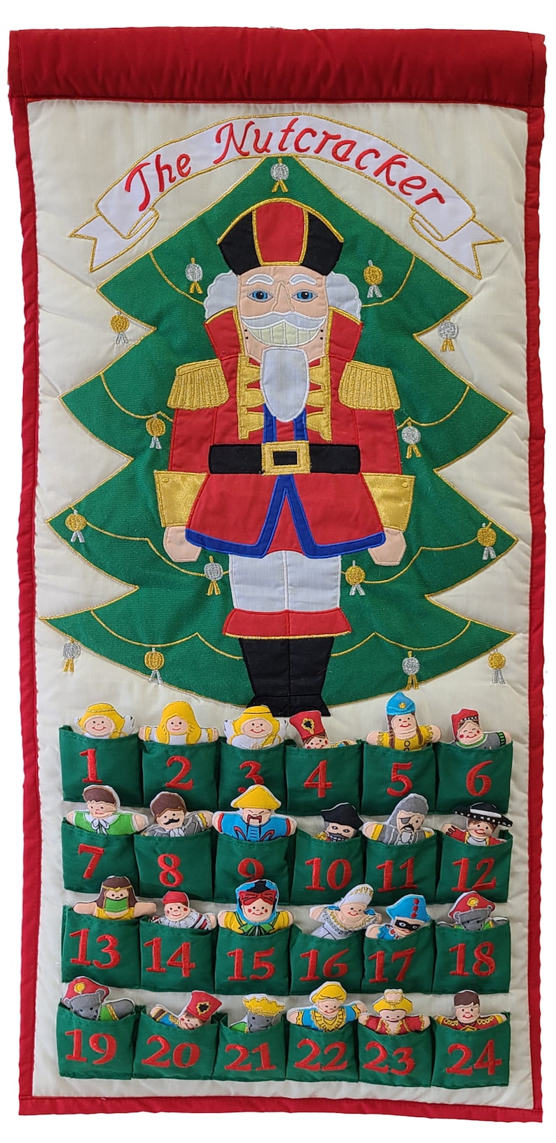 May include: A green felt advent calendar with 24 pockets, each containing a different embroidered figure. The calendar features a large embroidered Nutcracker figure at the top, with the text "The Nutcracker" above it.