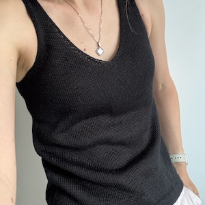 May include: A black sleeveless knitted tank top with a v-neck.
