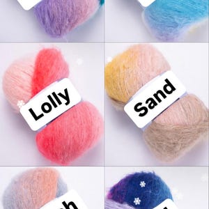 May include: Six skeins of yarn in various colors, including pink, blue, yellow, and gray. Each skein has a label with a different color name: Dream, Sky, Lolly, Sand, Peach, and Wind.
