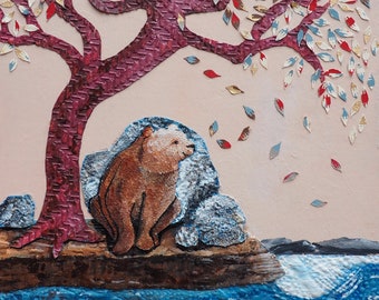 May include: Mixed media artwork featuring a brown bear sitting near a tree with red, gold, and blue leaves. The tree has a textured, burgundy trunk. A blue textured body of water is in the foreground, with a white moon in the background.