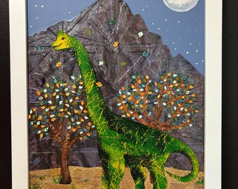 May include: A framed mixed-media artwork featuring a green long-necked dinosaur standing in a landscape with two trees, a large dark mountain, and a white moon against a blue starry sky. The dinosaur has yellow accents and textured skin.