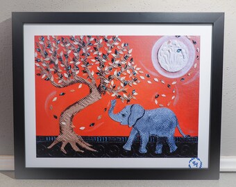 May include: Framed art print featuring a blue elephant under a tree with falling leaves against an orange background. The tree has brown bark and silver and blue leaves. A white moon is in the upper right corner.