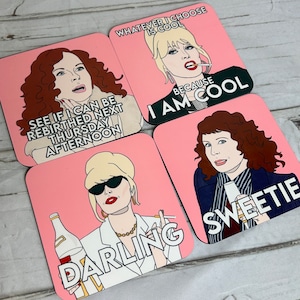 May include: Four pink square coasters with black outlines and white text. Each coaster features a different character from the television show AbFab. The first coaster features the character Patsy with the text "Whatever I choose is cool because I am cool". The second coaster features the character Edina with the text "See if I can be rebirthed next Thursday afternoon". The third coaster features the character Patsy with the text "Darling". The fourth coaster features the character Edina with the text "Sweetie".