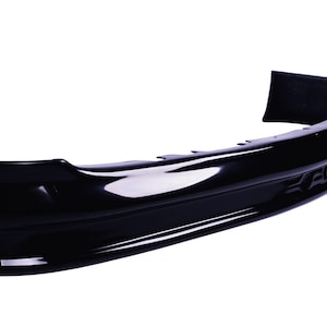 May include: Black plastic car rear bumper with a smooth, glossy finish. The bumper has a slight curve and a small lip on the bottom edge. The word "ELAN" is embossed on the right side of the bumper.