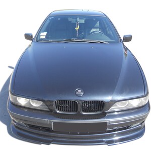 Puede incluir: Un sed&aacute;n BMW Serie 5 negro con un aler&oacute;n de parachoques delantero y una parrilla negra. El coche tiene una pintura negra y un interior negro.