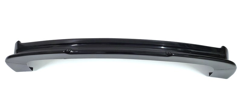 Puede incluir: Un aler&oacute;n de coche de pl&aacute;stico negro con un dise&ntilde;o curvo. El aler&oacute;n tiene un acabado liso y brillante.