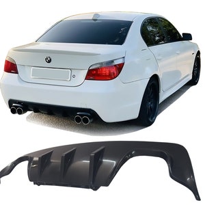 May include: A black rear diffuser with four fins for a BMW 5 Series saloon. The diffuser is made of a durable material and is designed to improve the car's aerodynamics and performance.