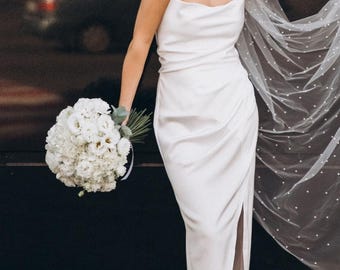 Elegante vestido de novia de satén con corsé en la espalda y abertura hasta el muslo