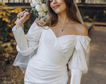Elegante vestido de novia de satén real: mangas abullonadas y abertura en el muslo.