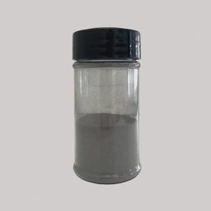 May include: A clear, cylindrical spice jar with a black lid, filled with a gray powder. The jar is transparent, allowing the contents to be visible. The powder fills about half of the jar.