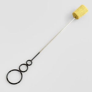 Puede incluir: Un accesorio de poi de fuego con una mecha cilíndrica amarilla y una serie de anillos negros. La mecha está unida a una varilla plateada, que se conecta a los anillos. Los anillos son de diferentes tamaños.