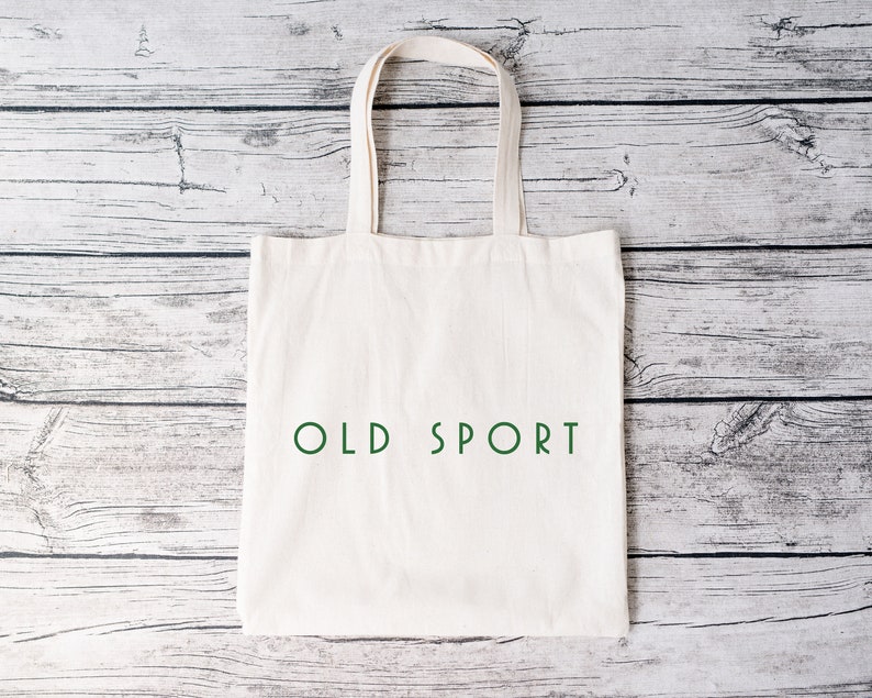 K&ouml;nnte beinhalten: Eine wei&szlig;e Stofftasche mit dem Text "OLD SPORT" in Gr&uuml;n auf der Vorderseite.