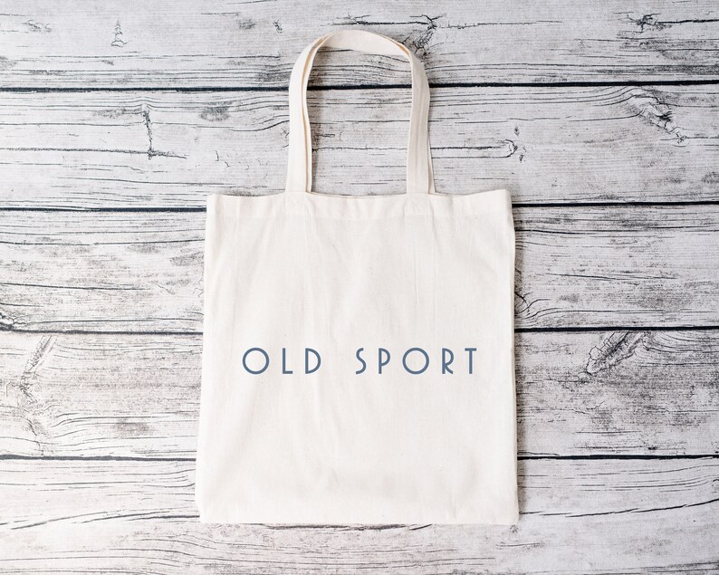 K&ouml;nnte beinhalten: Wei&szlig;e Stofftasche mit dem Aufdruck "OLD SPORT" in Blau.