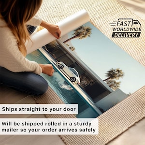 May include: A rolled art print featuring a white car parked near a pool and modern architecture, with palm trees in the background. The print is being unrolled. Text on the image reads "Ships straight to your door" and "Will be shipped rolled in a sturdy mailer so your order arrives safely."