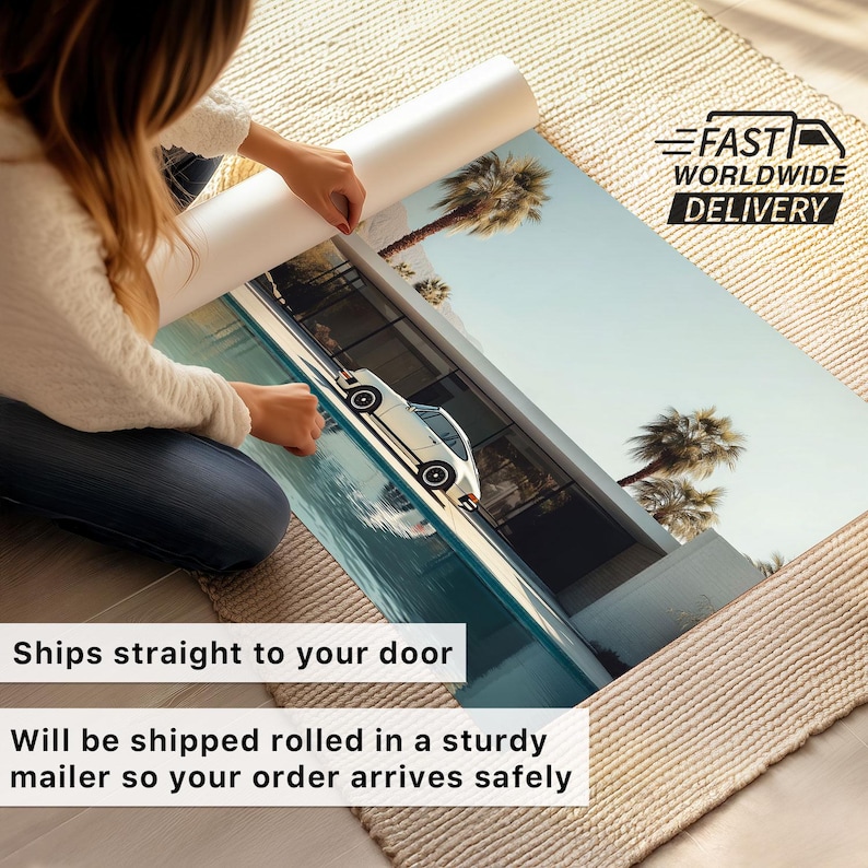 May include: A rolled art print featuring a white car parked near a pool and modern architecture, with palm trees in the background. The print is being unrolled. Text on the image reads "Ships straight to your door" and "Will be shipped rolled in a sturdy mailer so your order arrives safely."